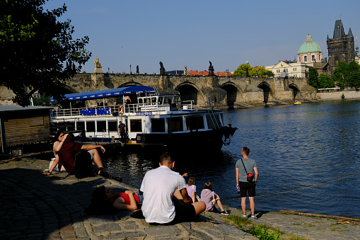 People relax in promenade of Vltava river in Prague, Czech Republic on July 27, 2022.
