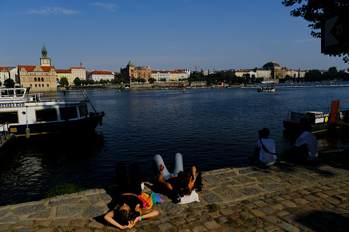 People relax in promenade of Vltava river in Prague, Czech Republic on July 27, 2022.