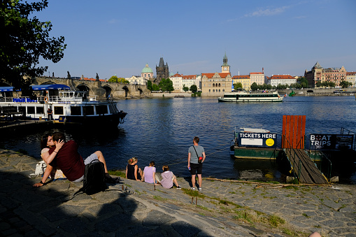 People relax in promenade of Vltava river in Prague, Czech Republic on July 27, 2022.