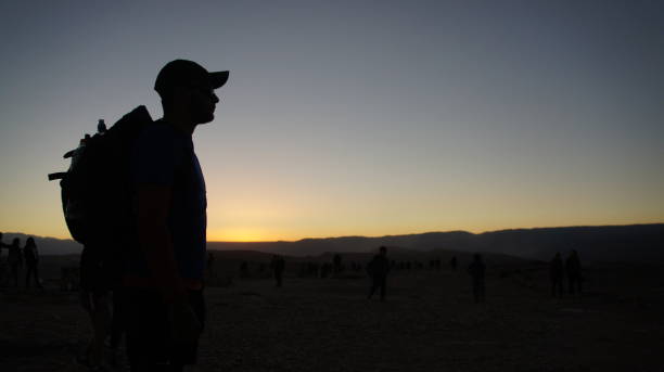 istock Man from the side, standing looking at infinity with sunset in the background 1444197502