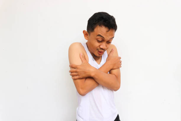 istock Freezing man, funny young man feels very cold wearing undershirt on white background. 1444199379