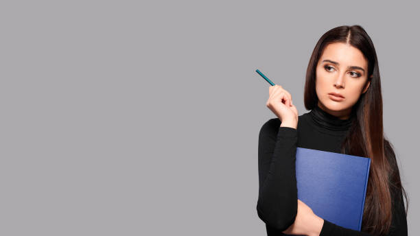 istock Young woman with notepad and pen over gray isolated background 1444199443