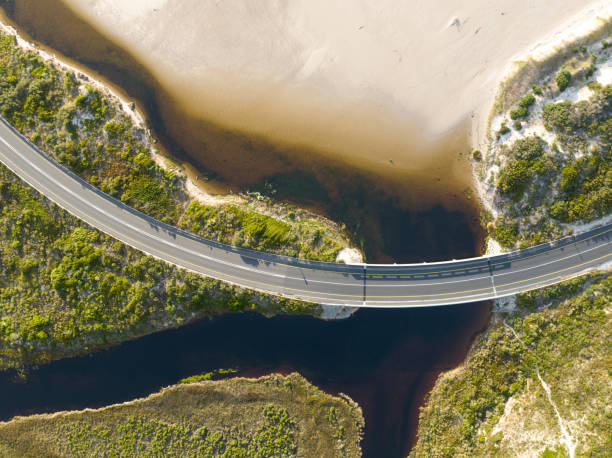 istock Overhead view road crosses over river mouth on coastline 1444199773