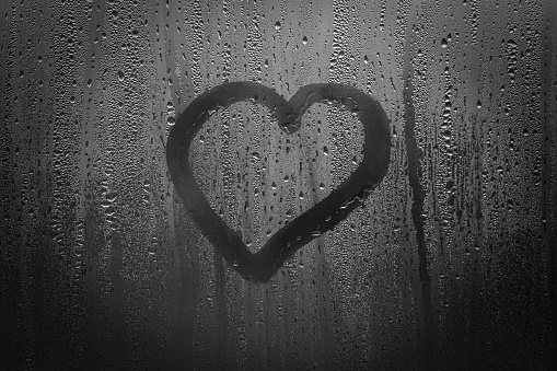 a heart on a misted window, a heart drawn with a finger on a window