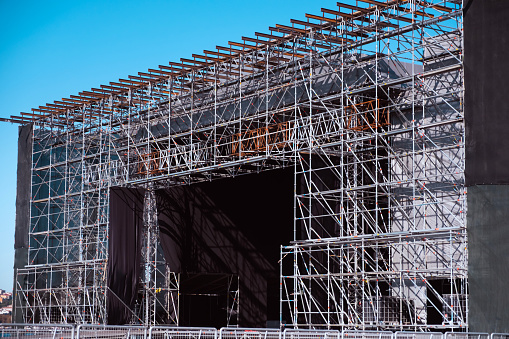 istock Installation of professional concert equipment. Lifting of line array speakers. Truss with spot lighting equipment above the stage. 1444204949