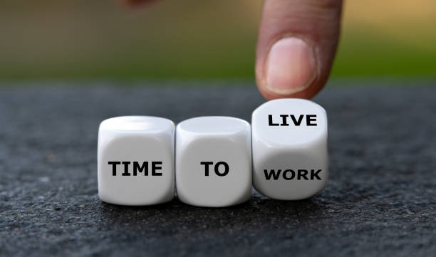 istock Hand turns dice and changes the expression 'time to work' to 'time to live'. 1444206279