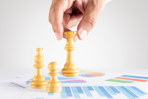 Business strategy concept with chess pieces and financial figures and graphs