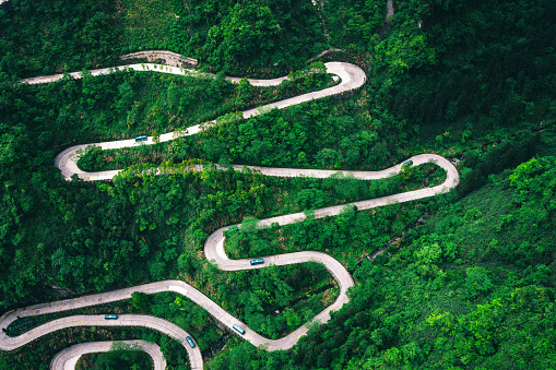 Passo di Giau Green hills Aerial drone shot of curved mountainous snake road. Traveling, transportation, safety driving, traveling, car rental concept.