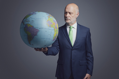 Corporate businessman holding a globe, global business and environmental protection concept