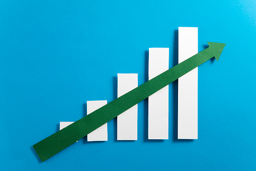 Growing bar graph with green colored rising arrow