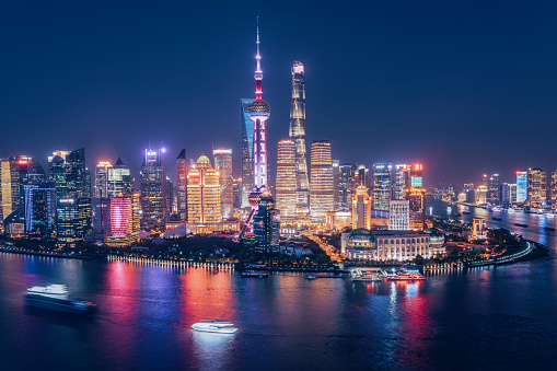 Aerial skyline view of Shanghai at dusk showing the financial district of Pudong and its tall skyscrapers.