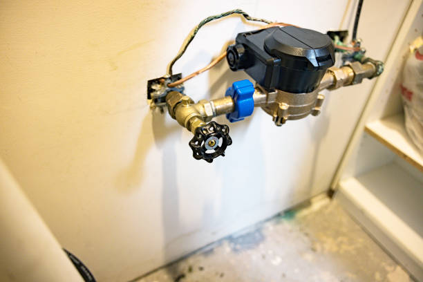 New, modern, innovative, wireless, digital, residential home water meter monitoring equipment recently installed in a basement cellar utility room. This meter is accessed and read wirelessly by the local water company to automatically and efficiently monitor and bill water pressure and usage. The new process no longer requires manual water meter reading, reporting, or any other intervention by a homeowner.