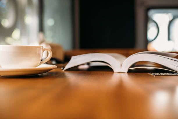 An open book and a cup of coffee on table