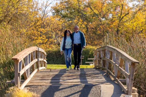 pareja en un hermoso parque - senior adult fun autumn senior couple fotografías e imágenes de stock