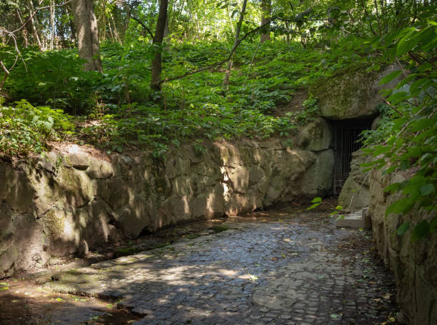 Stone grotto in the summer forest on a sunny day stock photo