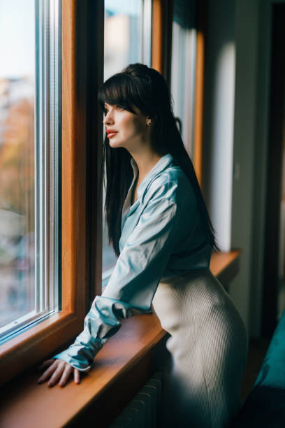 istock Woman daydreaming and looking through the window 1444238940