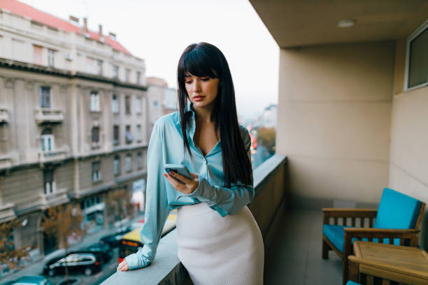 istock Young woman using a smartphone at the balcony 1444238967