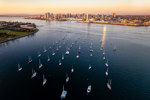View of Downtown San Diego California from Coronado Bridge during golden hour with boats in the bay. United States of America famous city skyline