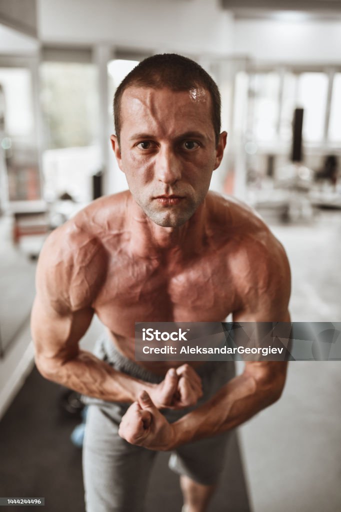 Male Bodybuilder Showing Muscular Build Progress In Gym Body Building Stock Photo