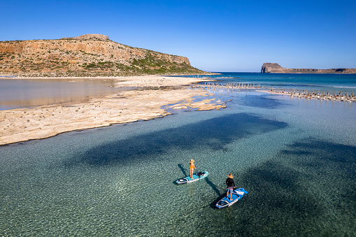 Paddle boarding at Balos Beach on Crete. Couple bonding through adventure in the outdoors.