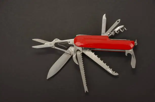 Open swiss army knife on a black background