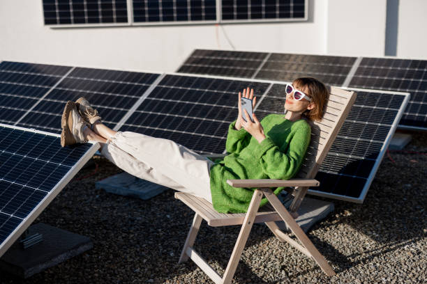 istock Happy woman on rooftop with a solar station 1444248182