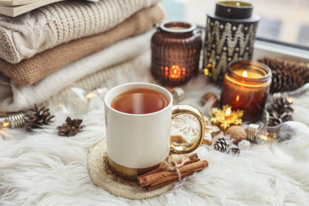 istock A cup of hot tea, burning candles and a stack of knitted sweaters on the windowsill, aesthetic photo 1444250064