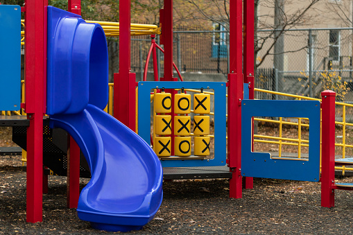 Playground with slide and tic-tac-toe game for children in park. Outdoor activities for kids.