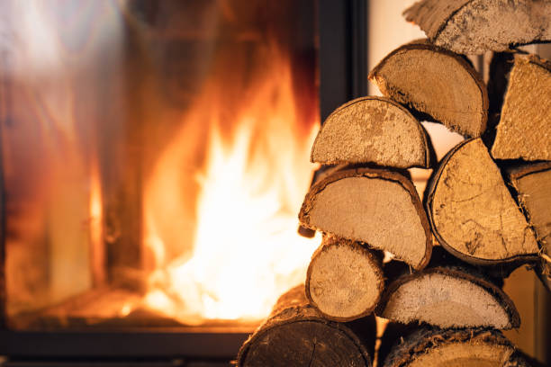 pila de leña frente a la estufa. - chimenea fotografías e imágenes de stock