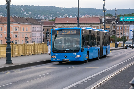 Budapest, Hungary - 2 September 2022: Blue city bus moving on Margaret Bridge