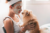 Beautiful teenage girl applying face mask at home