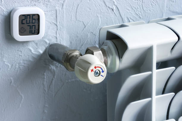 istock Heating radiator with temperature regulator. A thermometer that shows degrees and humidity in the apartment. Winter gas heating. 1444273020