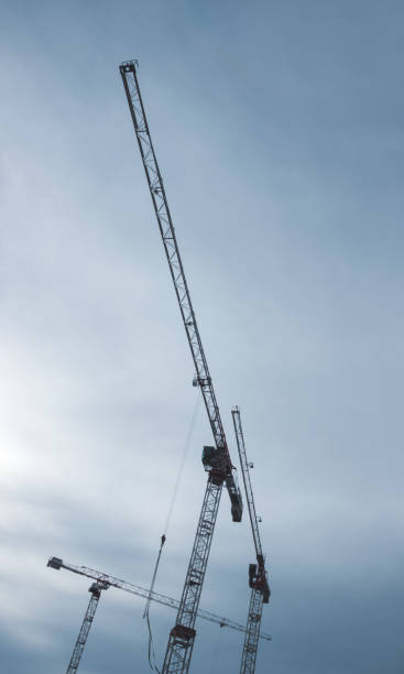 istock Construction site. A construction crane and a building under construction against a blue sky background. A construction crane is working, the walls of buildings are being erected. 1444278283