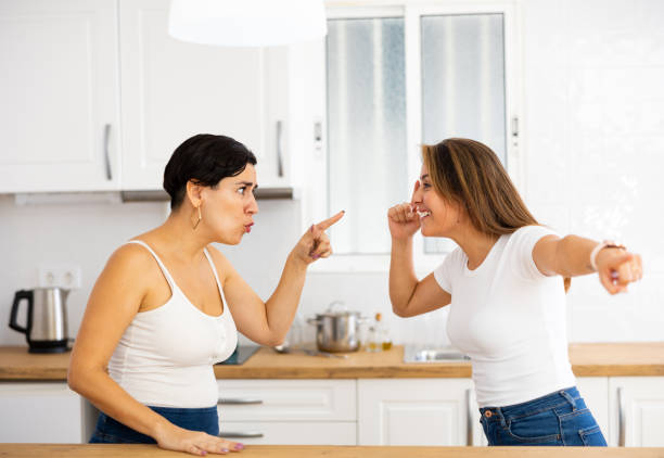 istock Two young Hispanic women emotionally arguing in kitchen 1444278536