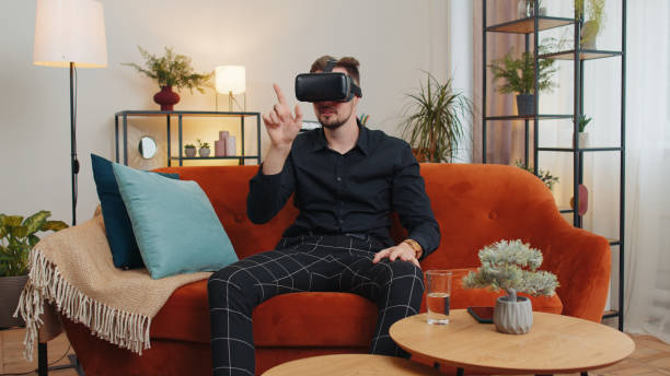 istock Young man use virtual reality headset glasses at home play 3D video game making gestures with hands 1444278762