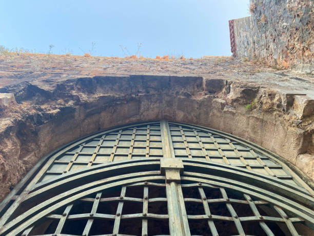 большие железные металлические ворота, проход, дверной проем, арка в старой древней средневековой крепости из булыжника и кирпича в теплой  - medieval castle gate portcullis стоковые фото и изображения