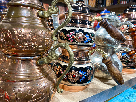 Beautiful golden Turkish teapots for tea shiny carved oriental decorative in a tourist souvenir shop.