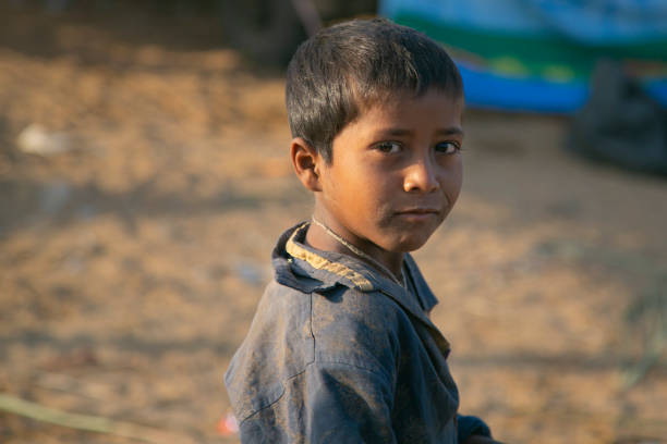 Portrait of a poor little boy at sunset.