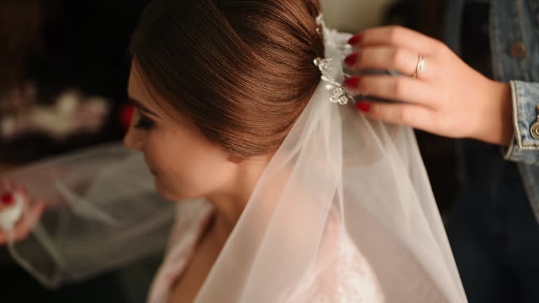 Hairdresser makes hairstyle beautiful girl in beauty salon. Head accessories close up.