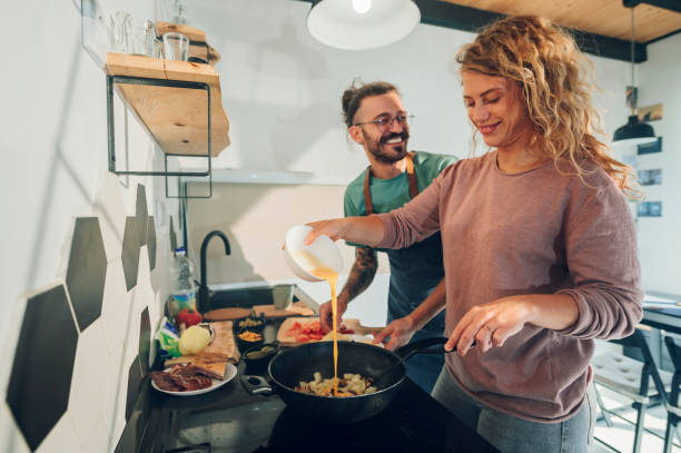 istock Young couple making breakfast together in the kitchen at home 1444281784