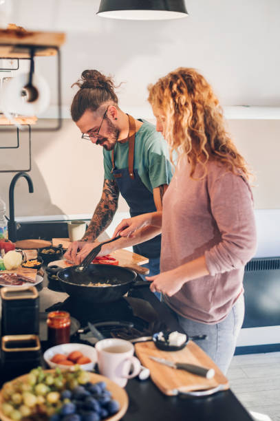 istock Young couple making breakfast together in the kitchen at home 1444281796
