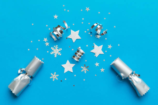 istock Christmas crackers with shiny confetti on color background, top view, copy space 1444283185