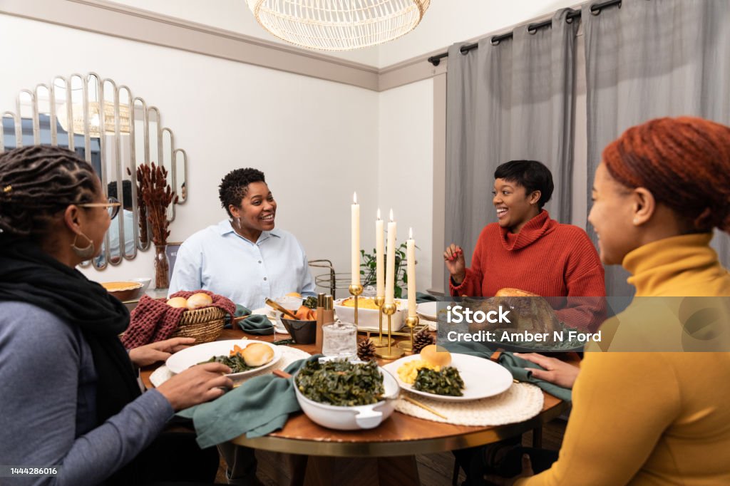 LGBT Friendsgiving two Black Lesbian couple join together in for a Thanksgiving dinner Dinner Stock Photo