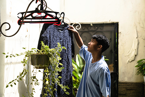 asian adult  hanging clothes on the line