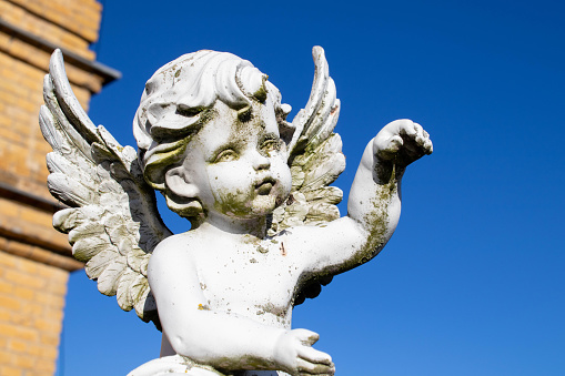 Guardian angel statue in light as a symbol of strength, truth and faith. Horizontal image.