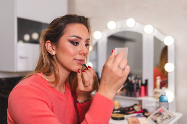 istock Beautiful young make-up artist applying make-up to her lips while looking in the mirror 1444289226
