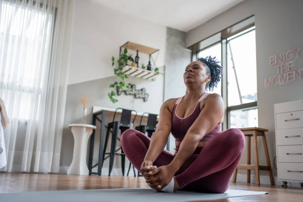 istock Black woman stretching at home 1444292323