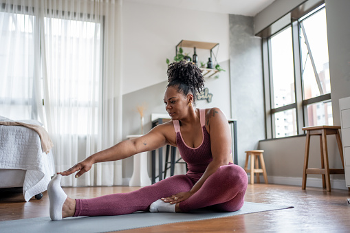 Black woman stretching at home
