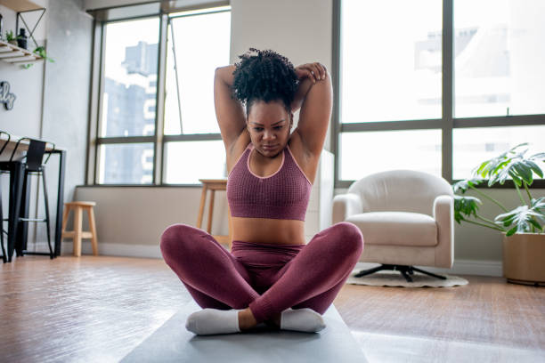 istock Black woman stretching at home 1444292425