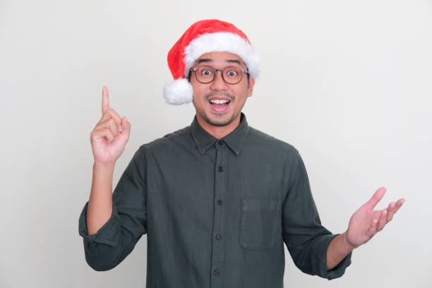 istock Asian man wearing Christmas hat pointing finger up with amazed expression 1444294812